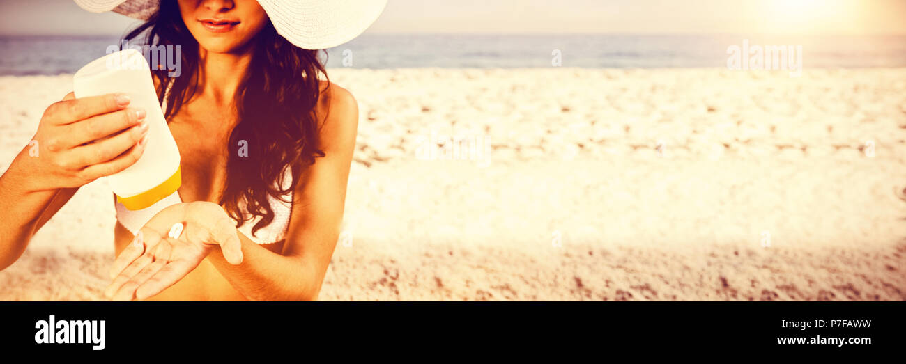 Giovani Sexy brunette prendersi cura del suo corpo mettendo in crema solare Foto Stock