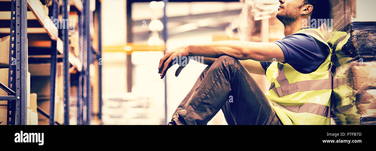 Stanco lavoratore manuale seduto sul pavimento Foto Stock