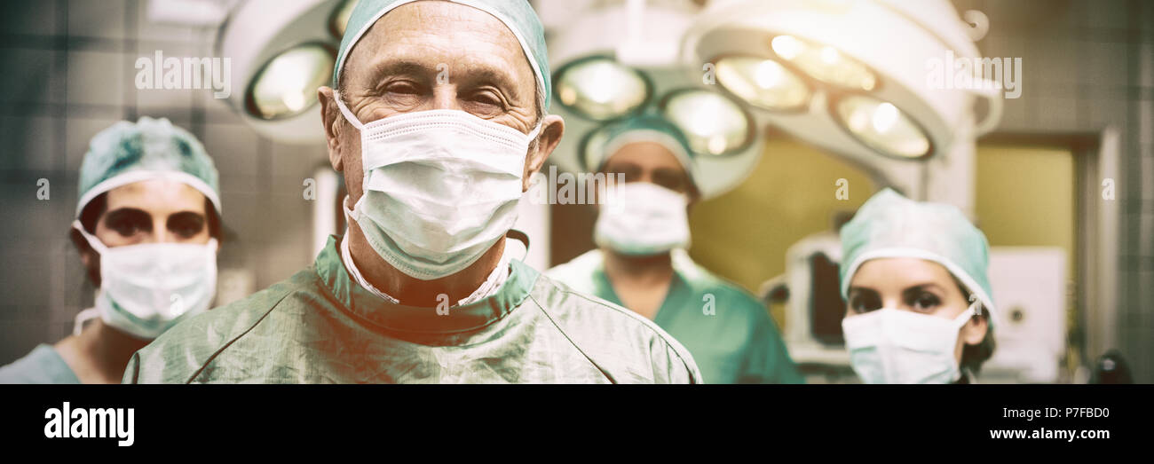 Chirurgo sorridente in posa con un team Foto Stock