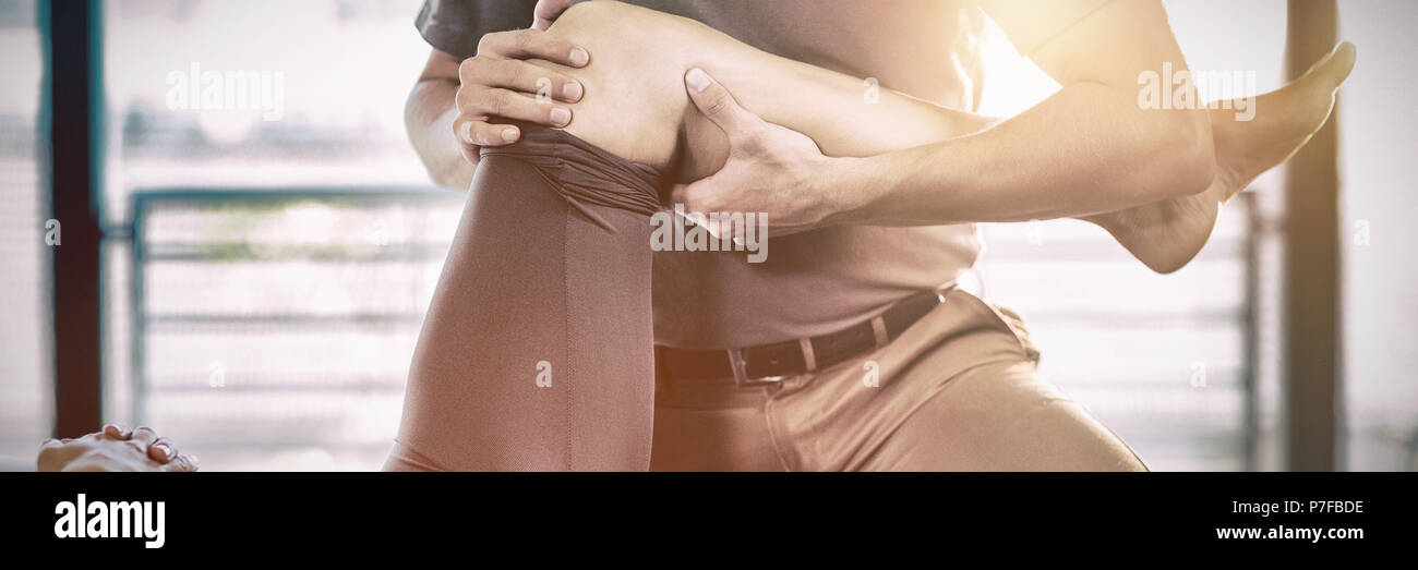 Fisioterapista dando la terapia al ginocchio di una donna Foto Stock