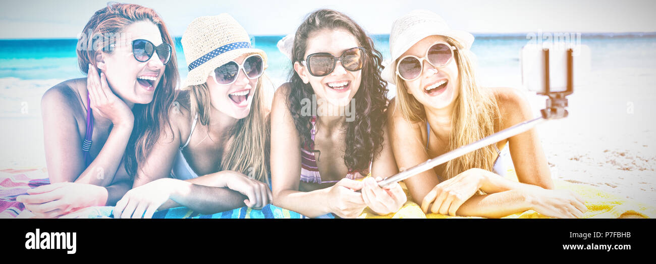 Felici donne tenendo selfie presso la spiaggia Foto Stock