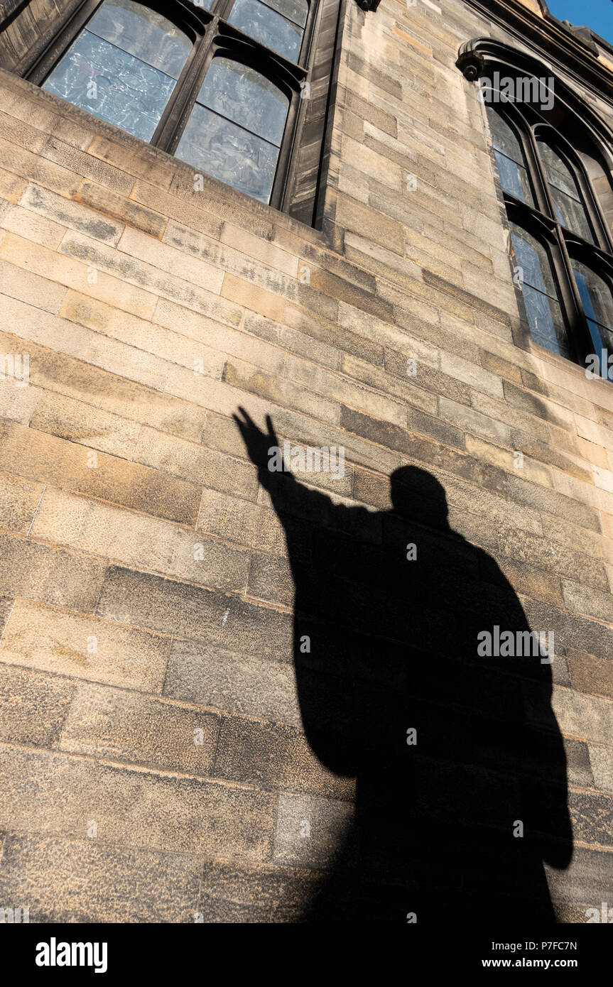 Ombra della statua di John Knox nel quadrilatero della New College dell'Università di Edimburgo, Scozia ,REGNO UNITO Foto Stock