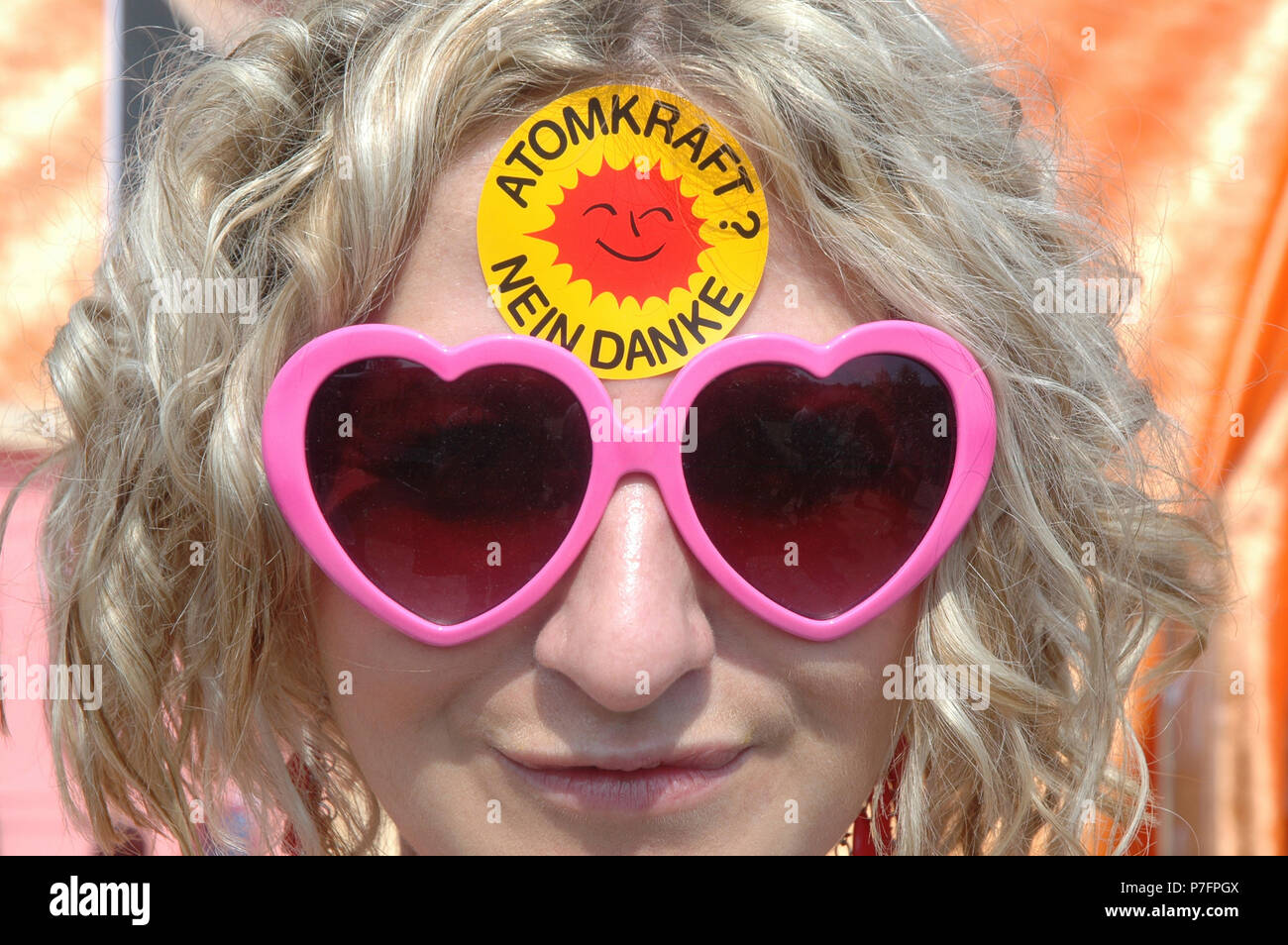 Ritratto di una donna con occhiali da sole e il nucleare No Grazie adesivo sulla sua fronte, Berlino, Germania Foto Stock