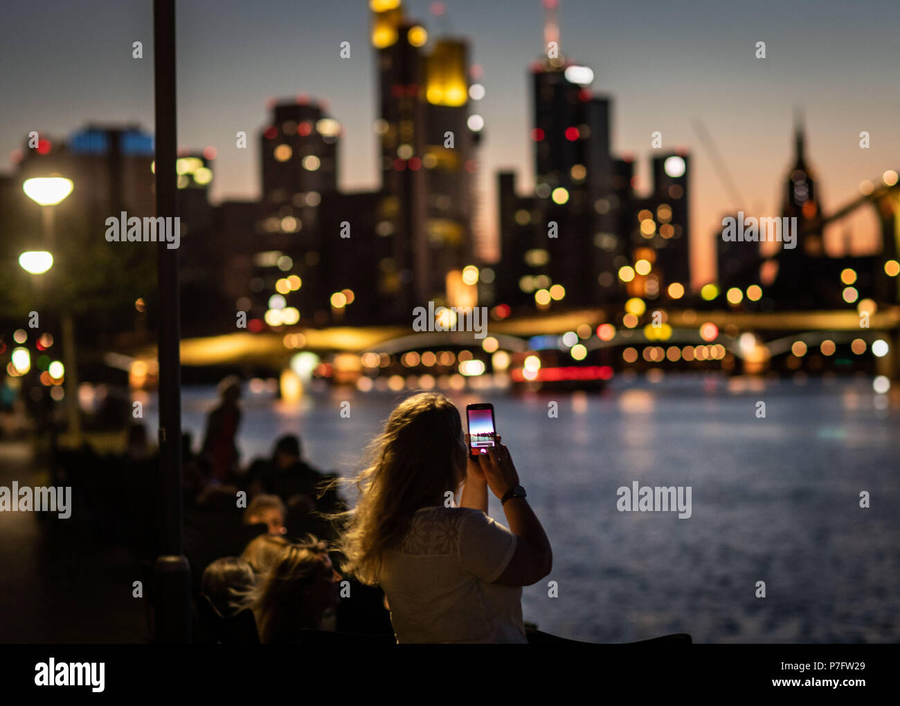 06/30/2018, Hesse, Frankfurt/Main: una donna prende una foto della skyline principale con il suo telefono cellulare con il suo telefono cellulare. Foto: Frank Rumpenhorst/dpa | Utilizzo di tutto il mondo Foto Stock