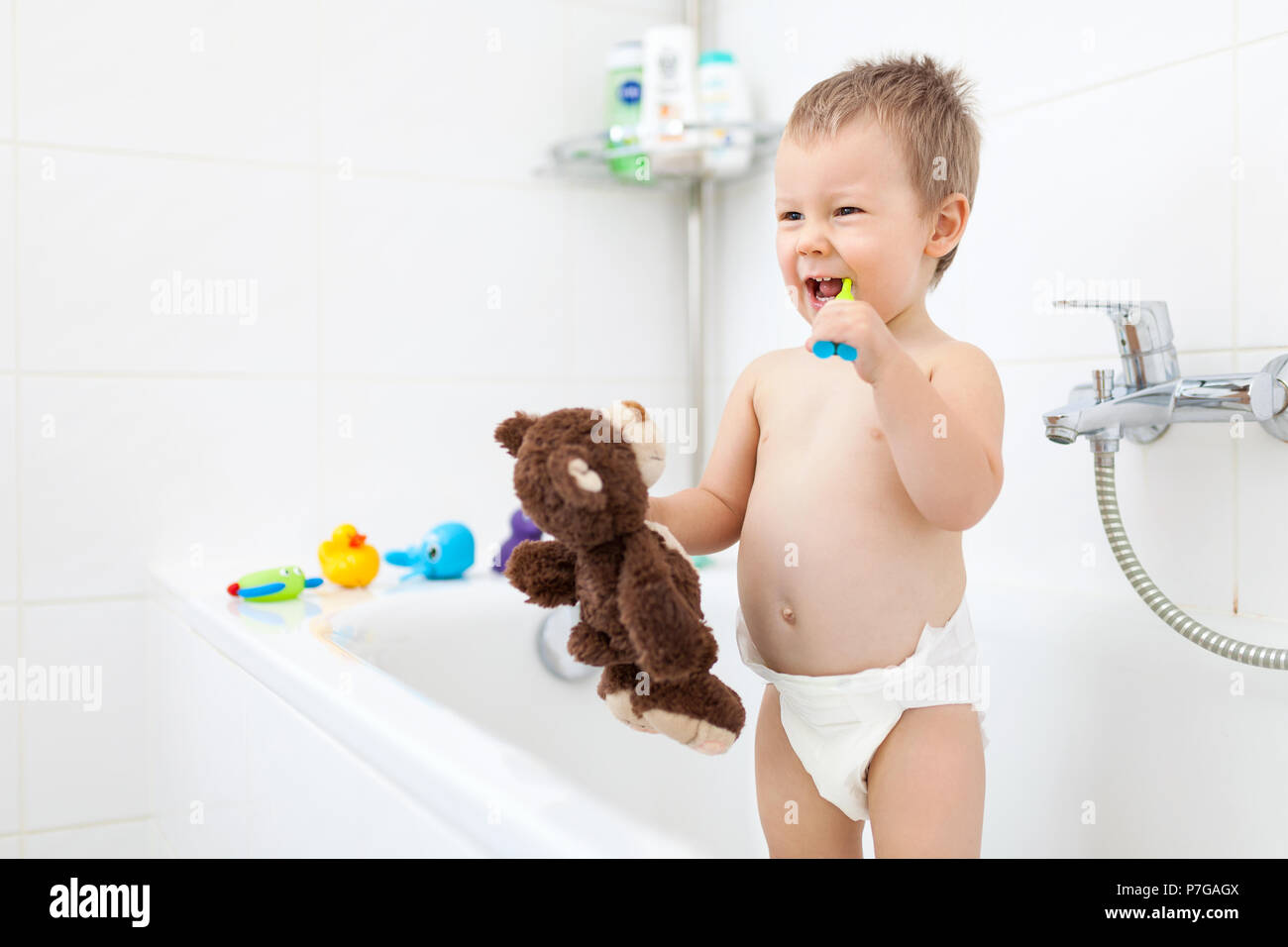 Adorabile bambino apprendendo come spazzolare i denti in bagno Foto Stock