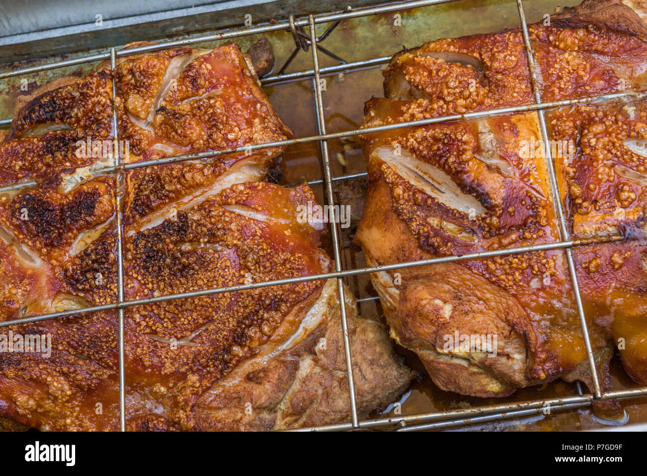 Pancetta di maiale alla griglia essendo in una fossa Foto Stock