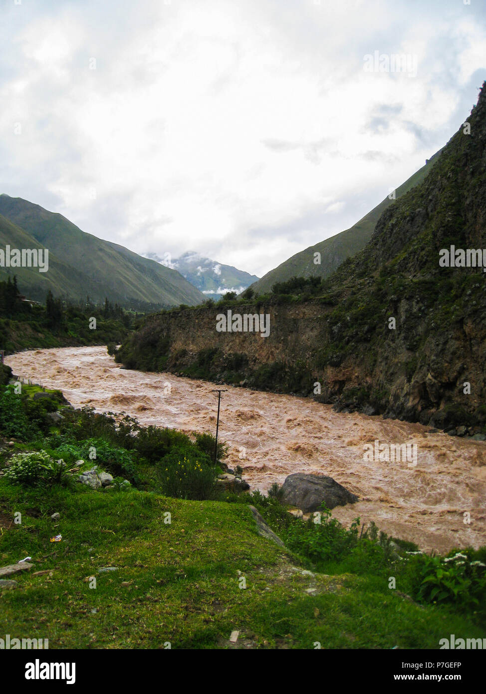 Fiume Urubamba, flusso di acqua nei pressi di Ollantaytambo villaggio nella Valle Sacra del Perù Sud, regione con una massiccia fortezza Inca con grandi terrazze in pietra o Foto Stock