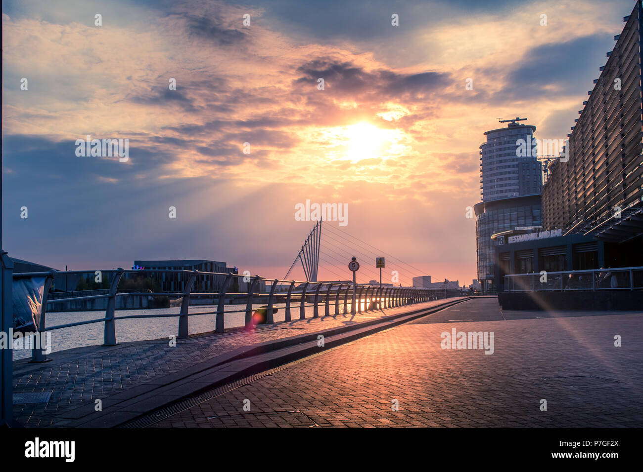 Un bellissimo tramonto celesti su Salford Quays, raggi di sole risplendere la luce si riflette al di fuori del reparto di vendita per formare una immagine gradevole. Foto Stock