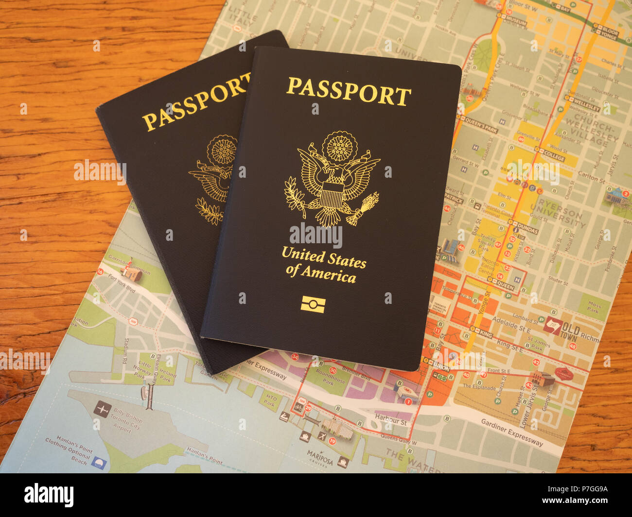 Noi due passaporti in cima a una mappa colorata. Fotografato dal di sopra su un tavolo di legno. Foto Stock