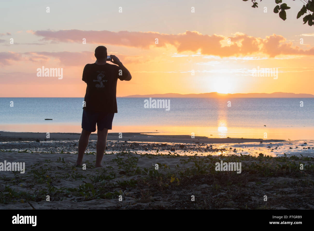 Silhouette di un maschio adulto di scattare una foto del tramonto, lealtà Beach, Seisia, Cape York Peninsula, estremo Nord Queensland, FNQ, QLD, Australia Foto Stock