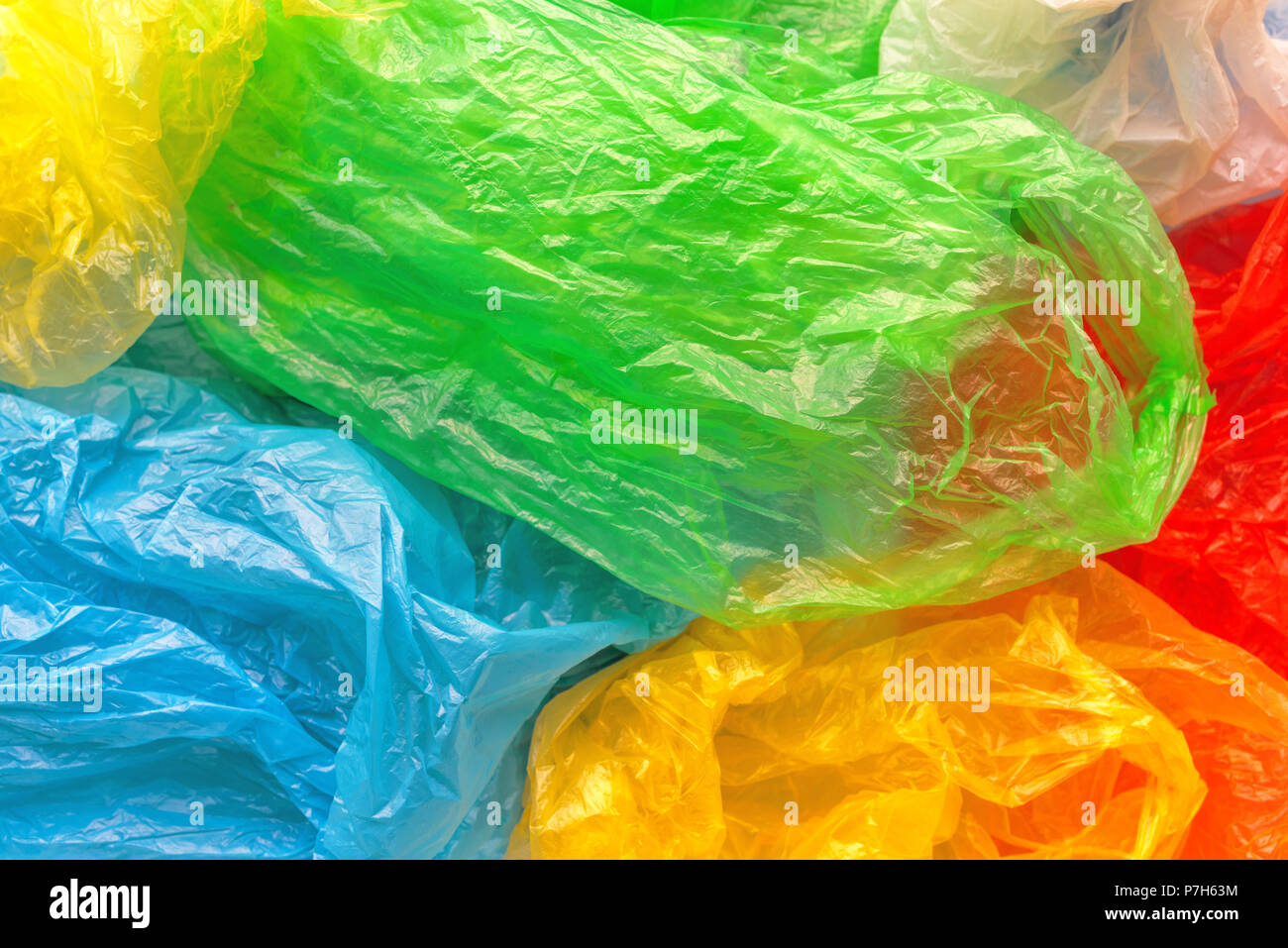 Pila di variopinti sacchetti di plastica, il consumismo e l'inquinamento ambientale concetto Foto Stock