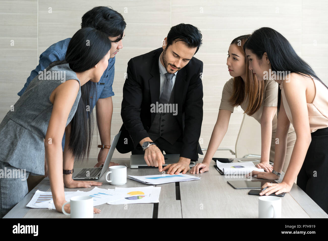 Smart manager spiegando riunione interna al suo team di progetto in un ufficio moderno. La multi etnico persona business group in tuta. Progetto e Business c Foto Stock