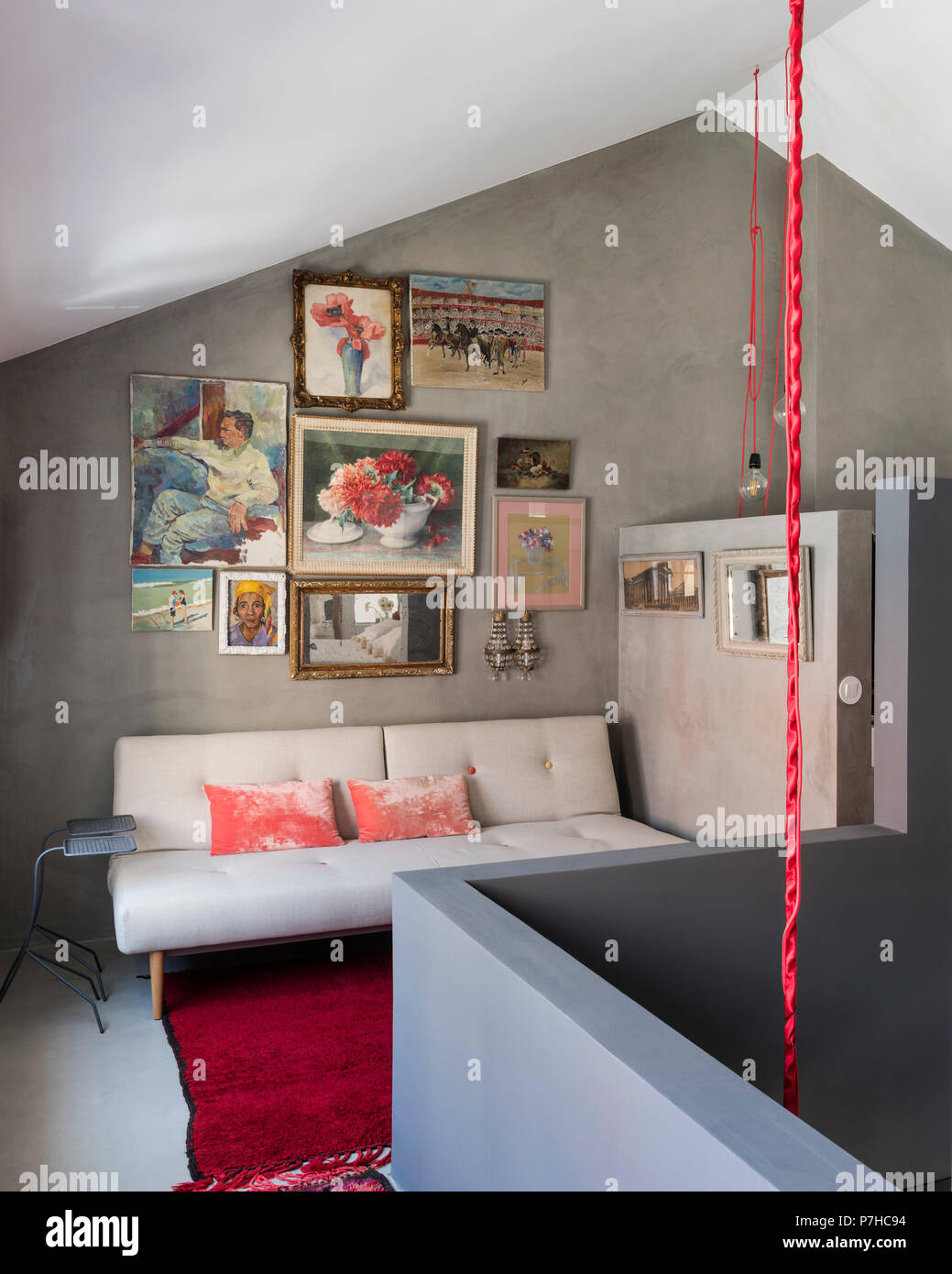 Coloratissimo mix di nature morte e ritratti sulla parete dell'area con posti a sedere in moderno stile loft Appartamento Foto Stock