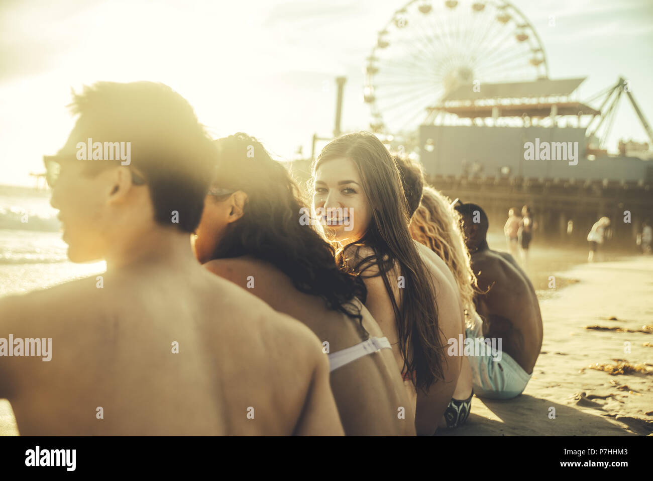 Gruppo di amici seduti sulla spiaggia Foto Stock