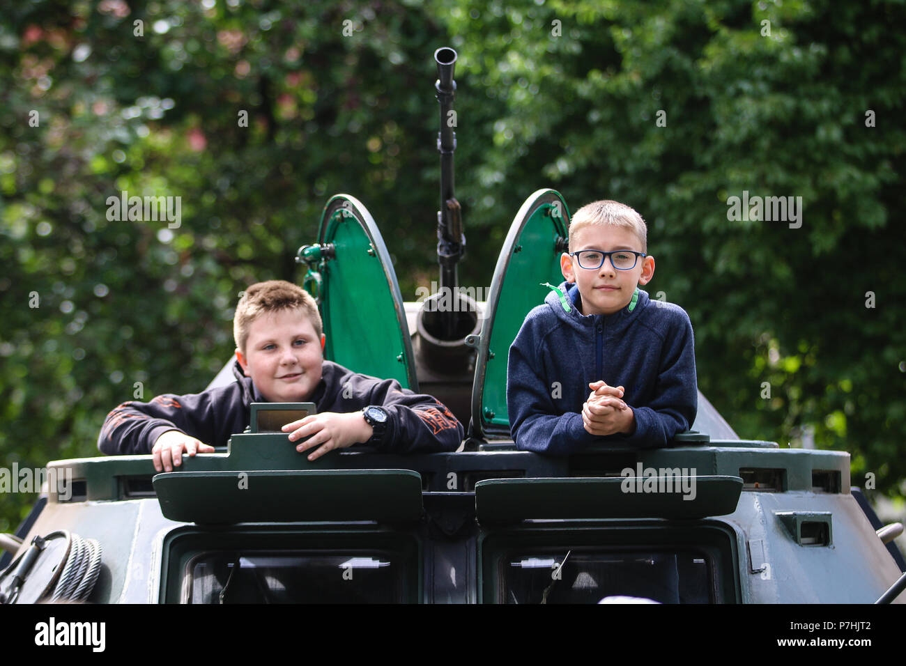 Due bambini polacchi guardano fuori dalla parte superiore di un BRDM-2 con ruote di comando anfibio veicolo dal polacco xv brigata meccanizzata, durante una visualizzazione statica con gruppo di combattimento della Polonia a Giżycko, Polonia il 30 giugno 2018. Gruppo di combattimento della Polonia è un luogo unico e multinazionale di coalizione di Stati Uniti, Regno Unito, croato e soldati rumeni che servono con il polacco della XV Brigata meccanizzata come una forza di dissuasione a sostegno della NATO in avanti rafforzata presenza. (U.S. Esercito foto di Spc. Hubert D. Delany III /22 Mobile degli affari pubblici distacco) Foto Stock