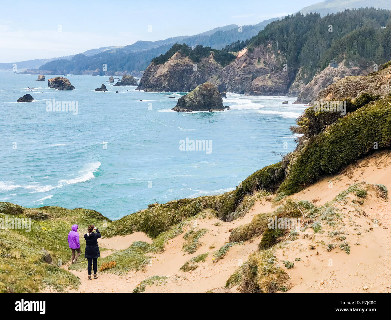 Due donne di prendere una foto di mare pile, Samuel H Boardman parco statale, Brookings, Oregon, America, STATI UNITI D'AMERICA Foto Stock