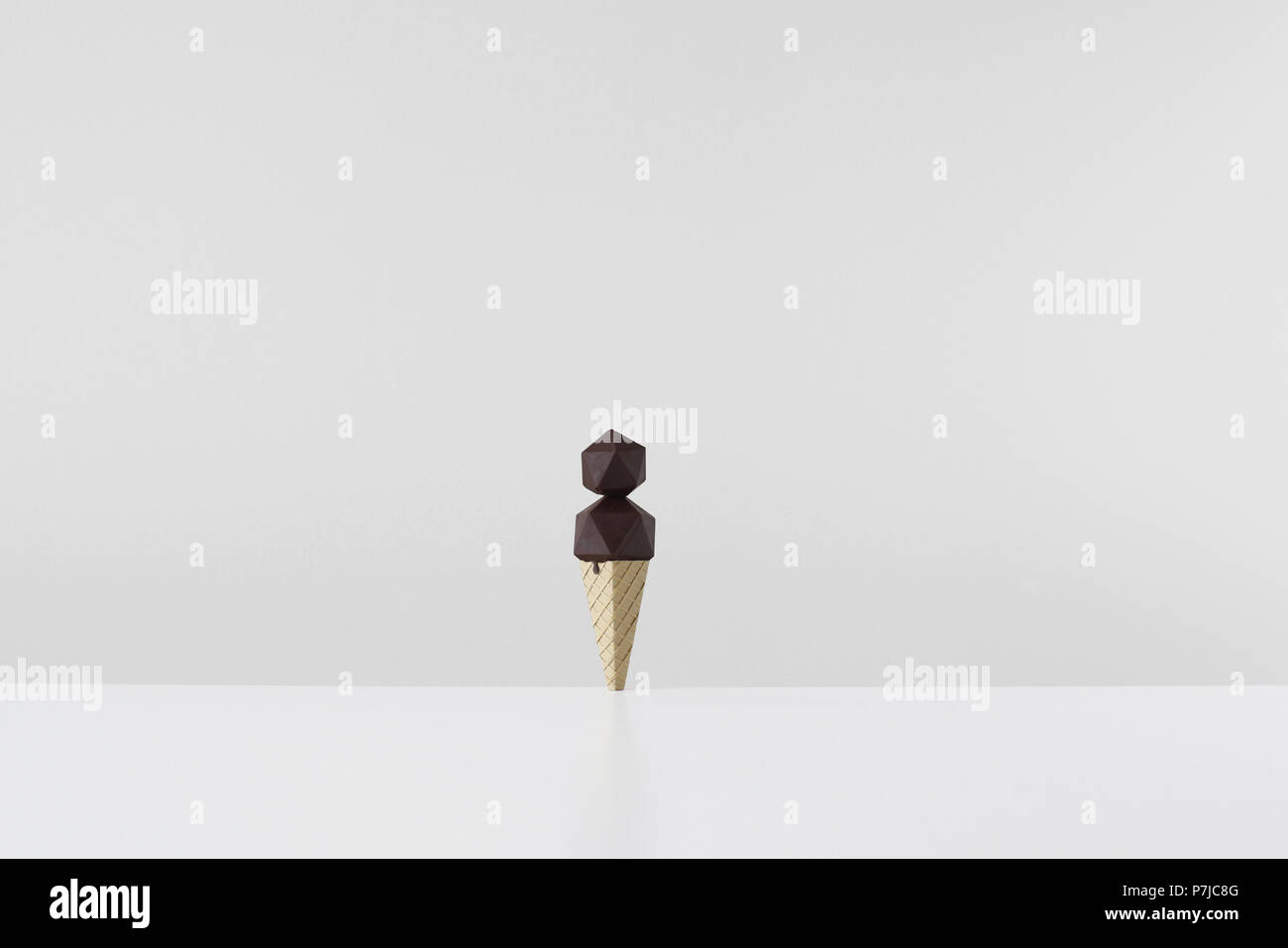 Forma geometrica origami di gelato al cioccolato nel cono di carta Foto Stock