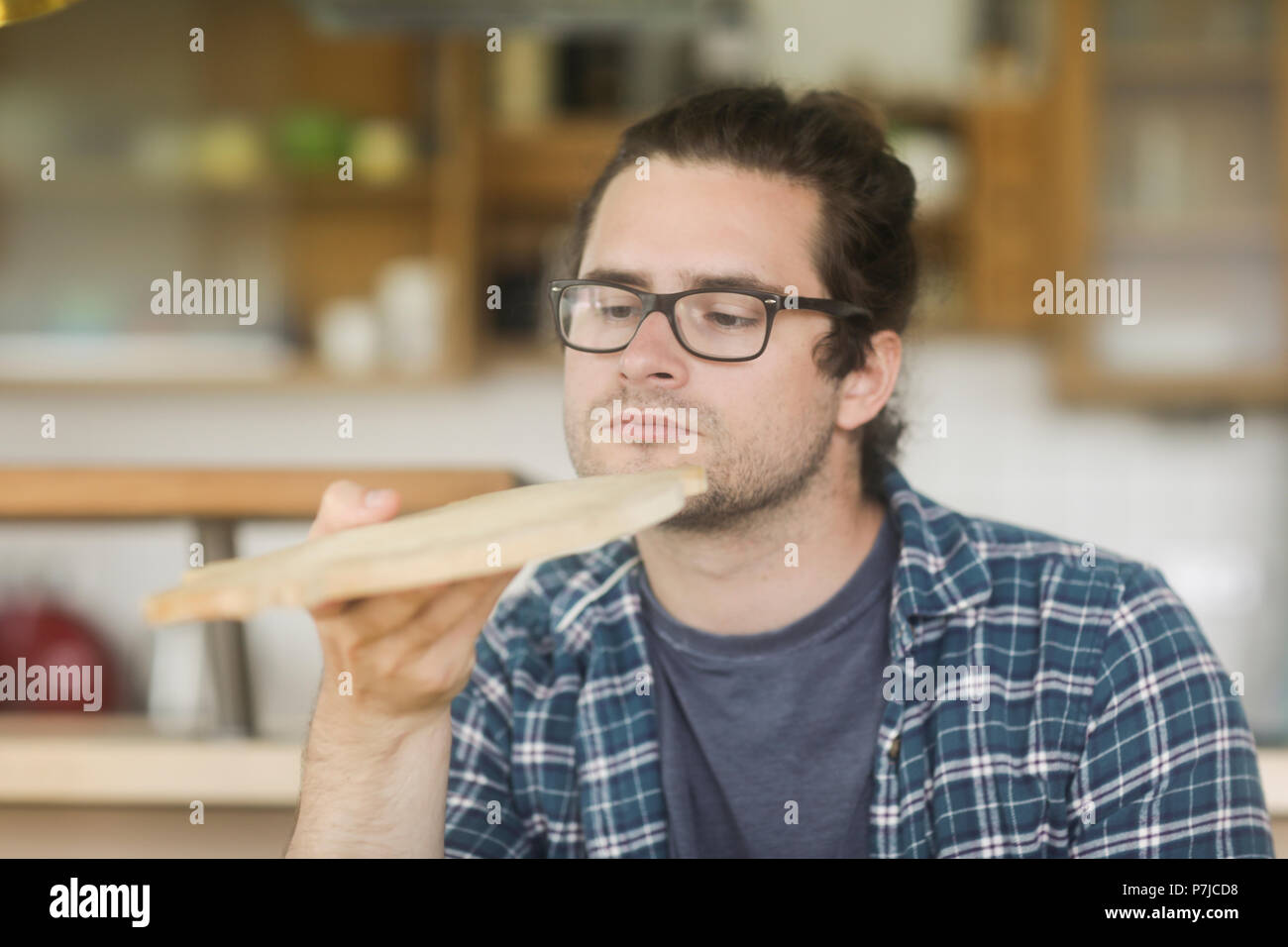 Uomo in piedi in cucina tenendo a casa tagliere Foto Stock