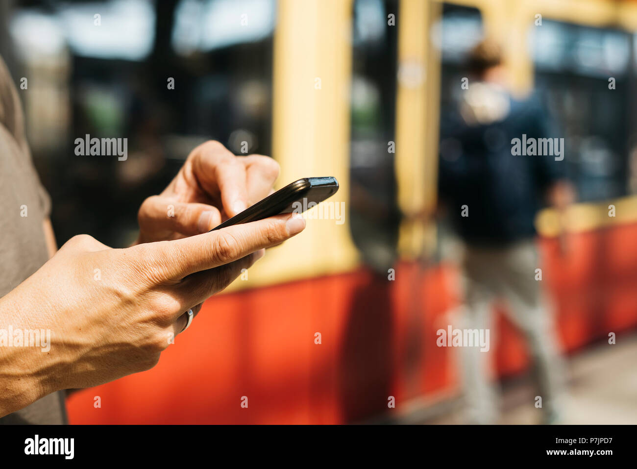Primo piano di un giovane uomo caucasico utilizzando uno smartphone in un treno della metropolitana o tram station Foto Stock