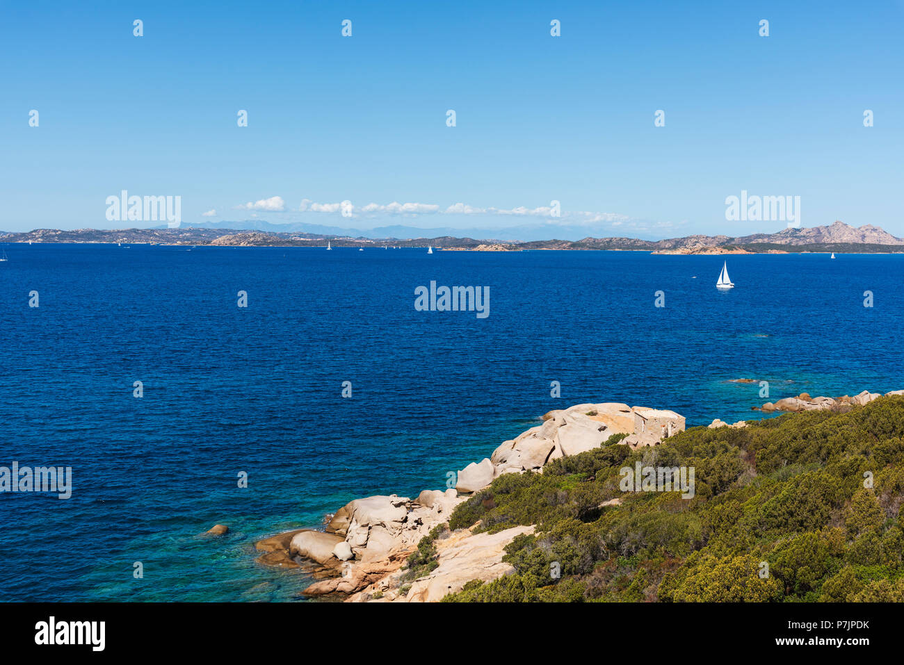 Una vista delle acque limpide del mare Mediterraneo e un gruppo di formazioni rocciose in una tranquilla spiaggia della costa di Baja Sardinia, nella famosa Costa Foto Stock