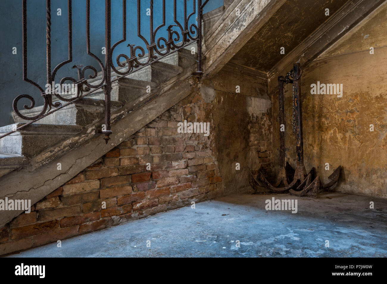 Vecchio arrugginito ancore sotto abbandonata scalinata in Venezia Foto Stock