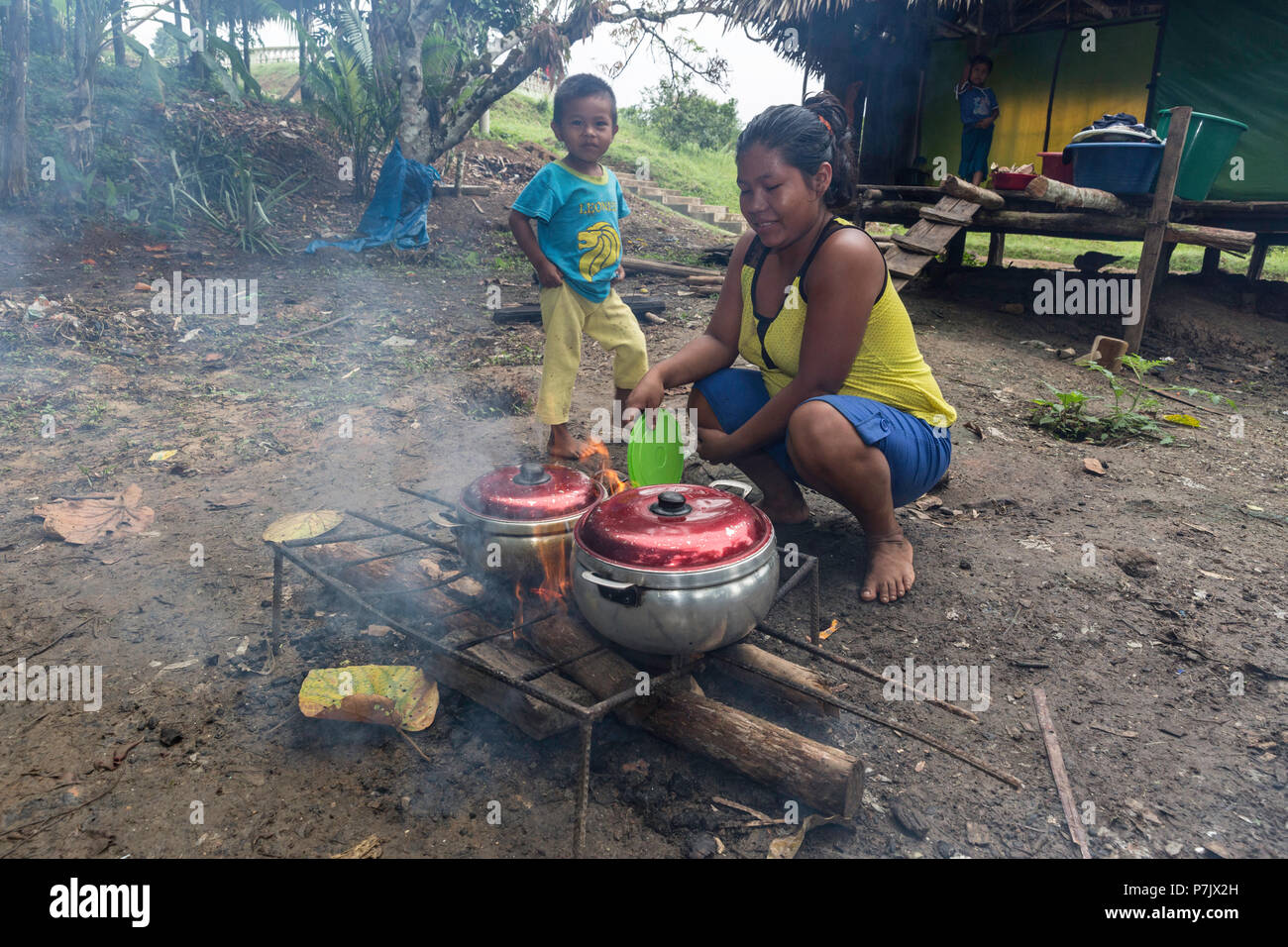 Donna preparare un pasto su un fuoco aperto, San Francisco Village, Loreto, Perù Foto Stock