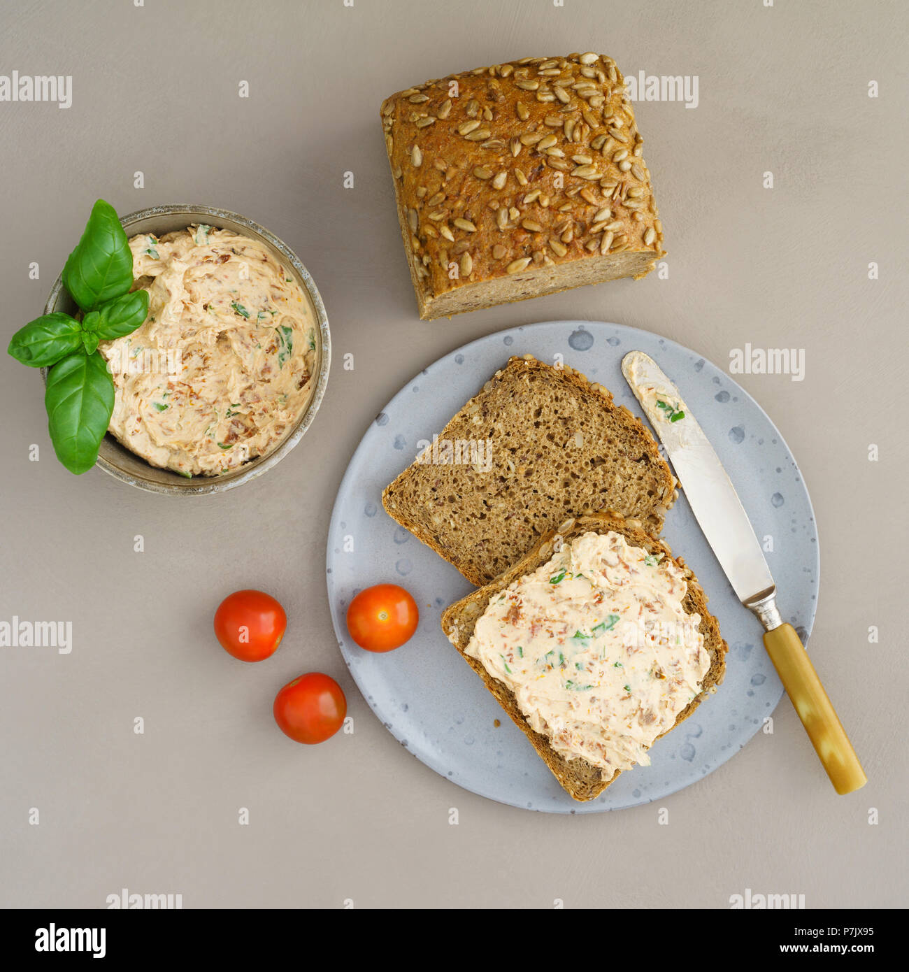 Multi-pane di grano di sandwich con crema di formaggio, pomodori e basilico diffusione Foto Stock