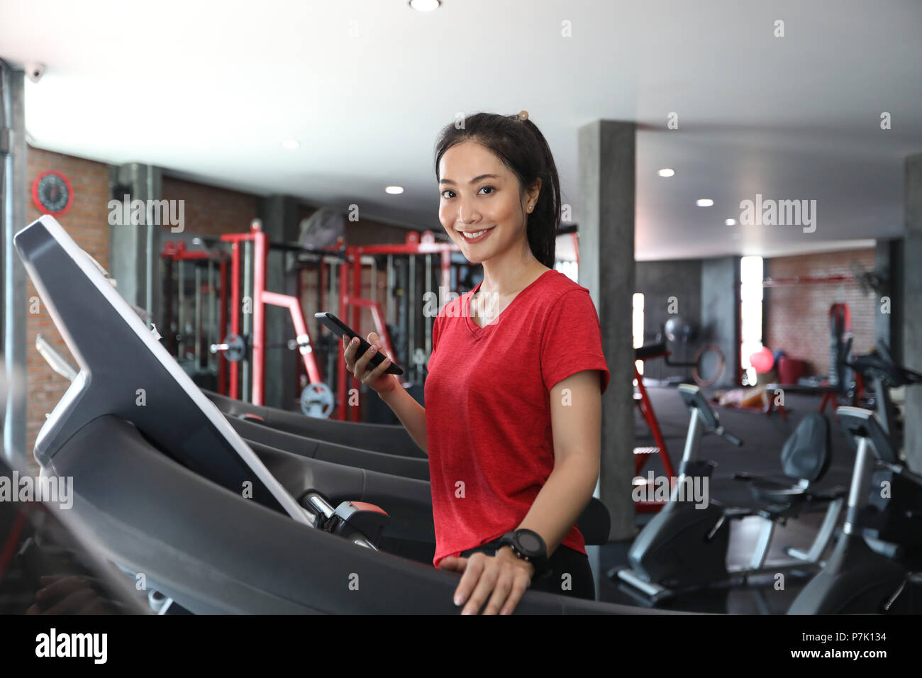 Donne asiatiche in esecuzione scarpe da ginnastica in palestra mentre una  giovane donna caucasica sta avendo il jogging sul tapis roulant Foto stock  - Alamy