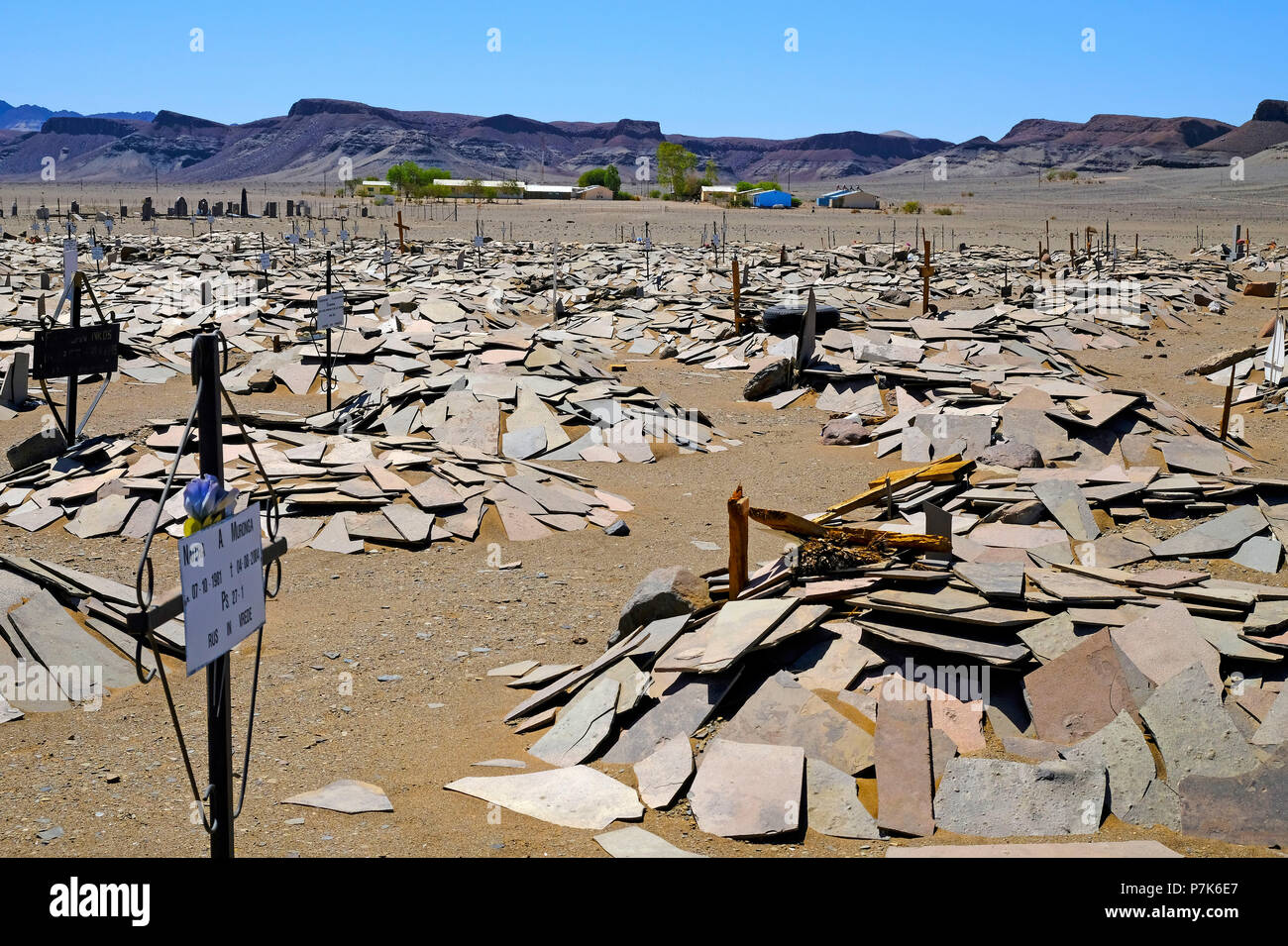 Tombe coperte con roccia sottili lastre di granito in un cimitero vicino la città di confine Noordoewer con le montagne sullo sfondo, Namibia, Noordoewer Foto Stock