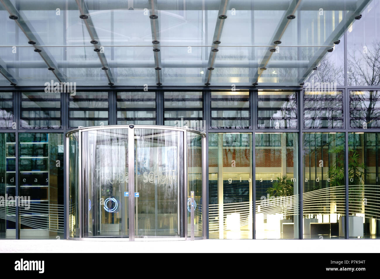 Ingresso in vetro della sede centrale della Schott AG a Mainz con una porta girevole e un tetto di vetro, Foto Stock