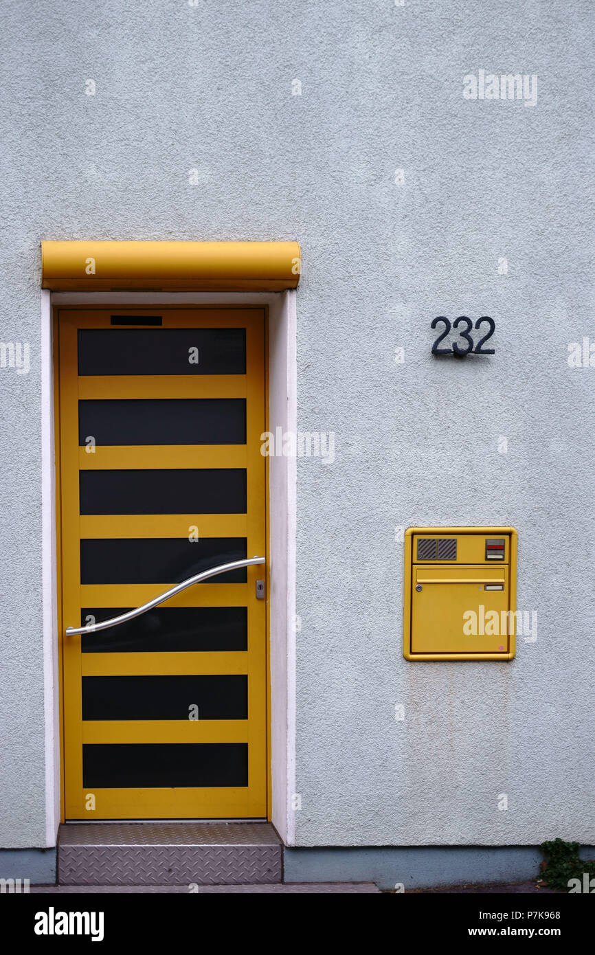 La moderna porta anteriore di un edificio residenziale con una curva in acciaio inossidabile e manico una buca delle lettere, Foto Stock