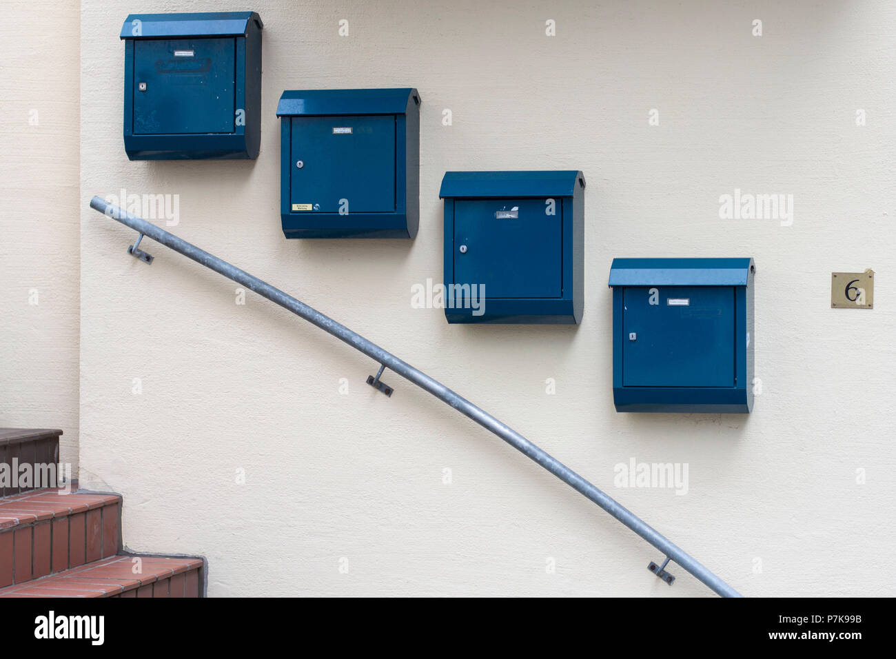 Caselle blu lungo una scala discendente della ringhiera. Foto Stock