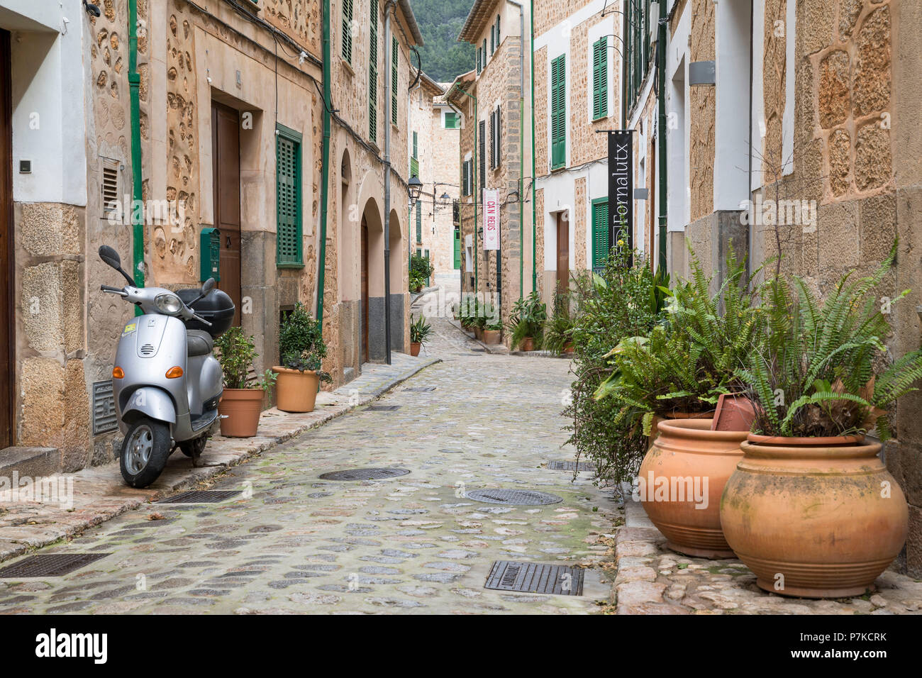 Parcheggiato scooter e vasi di piante in un vicolo in Fornalutx, Maiorca, isole Baleari, Spagna Foto Stock