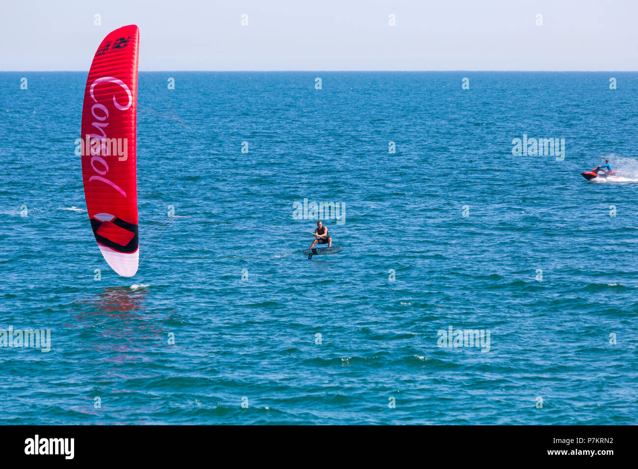 Bournemouth, Dorset, Regno Unito. 7th luglio 2018. Tempo nel Regno Unito: Un'altra calda giornata di sole mentre l'ondata di caldo continua e migliaia di amanti del sole si dirigano verso il mare per godersi le spiagge sabbiose di Bournemouth sulla costa meridionale con l'aumento delle temperature, anche con la grande partita! Kite surfer e jetski. Credit: Carolyn Jenkins/Alamy Live News Foto Stock