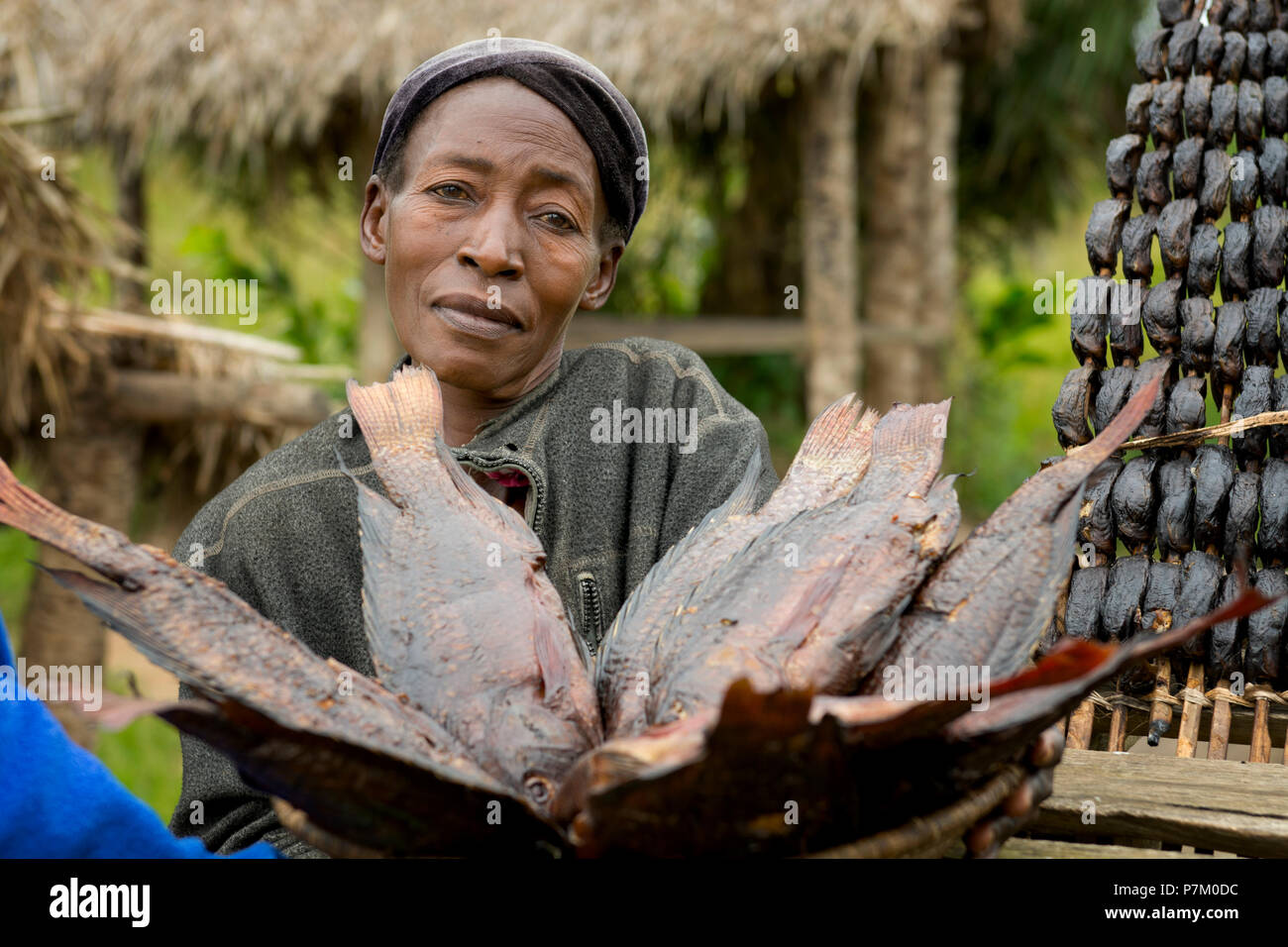Donna di vendita del pesce affumicato, Tilapia (Ngege), Strada venditore di pesce, venditore ambulante, fornitori Uganda Foto Stock