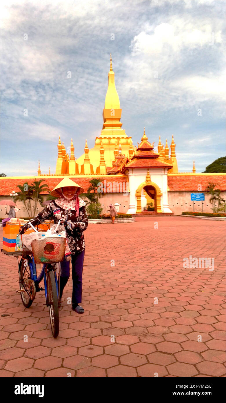 Un venditore era di muoversi con la bicicletta nel tempio, Vientiane Lao Foto Stock