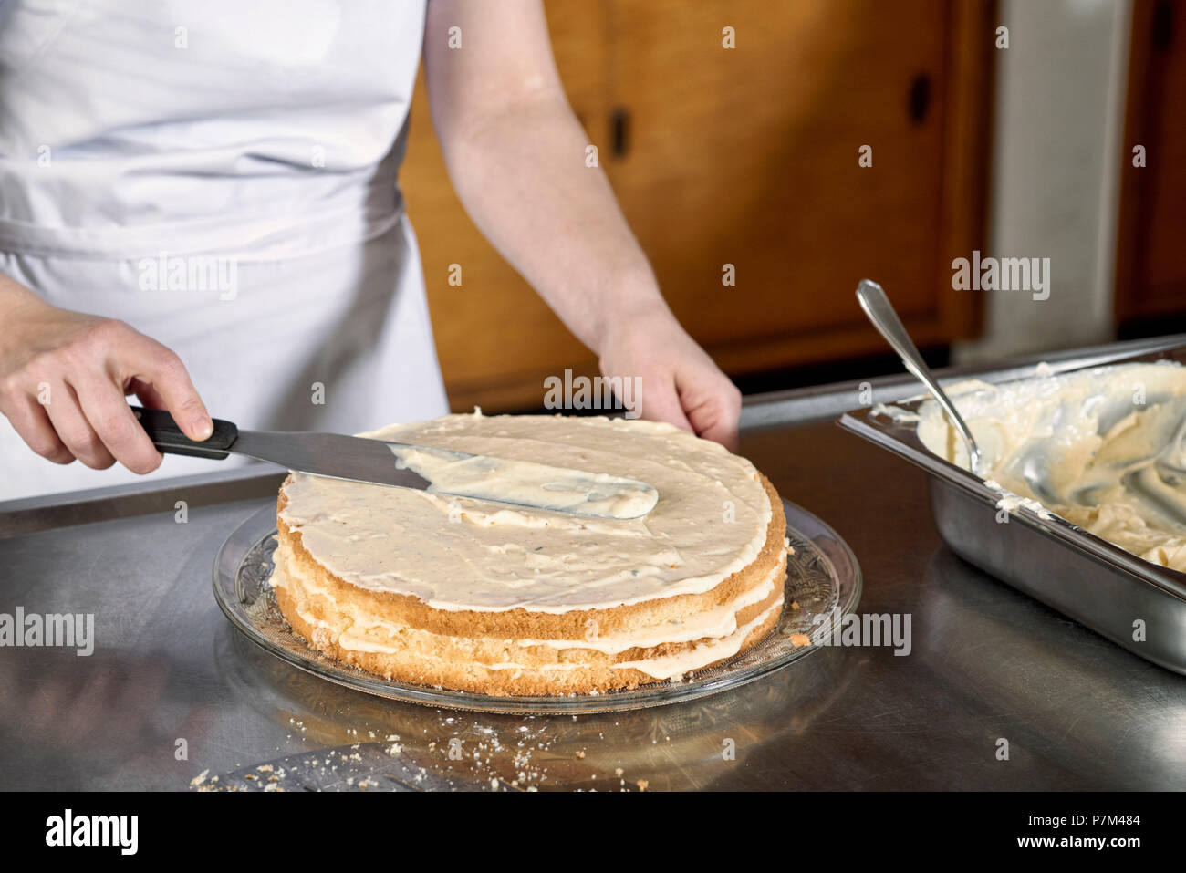 Passi per fare una torta di lamponi, diffondendo la crema alla vaniglia Foto Stock
