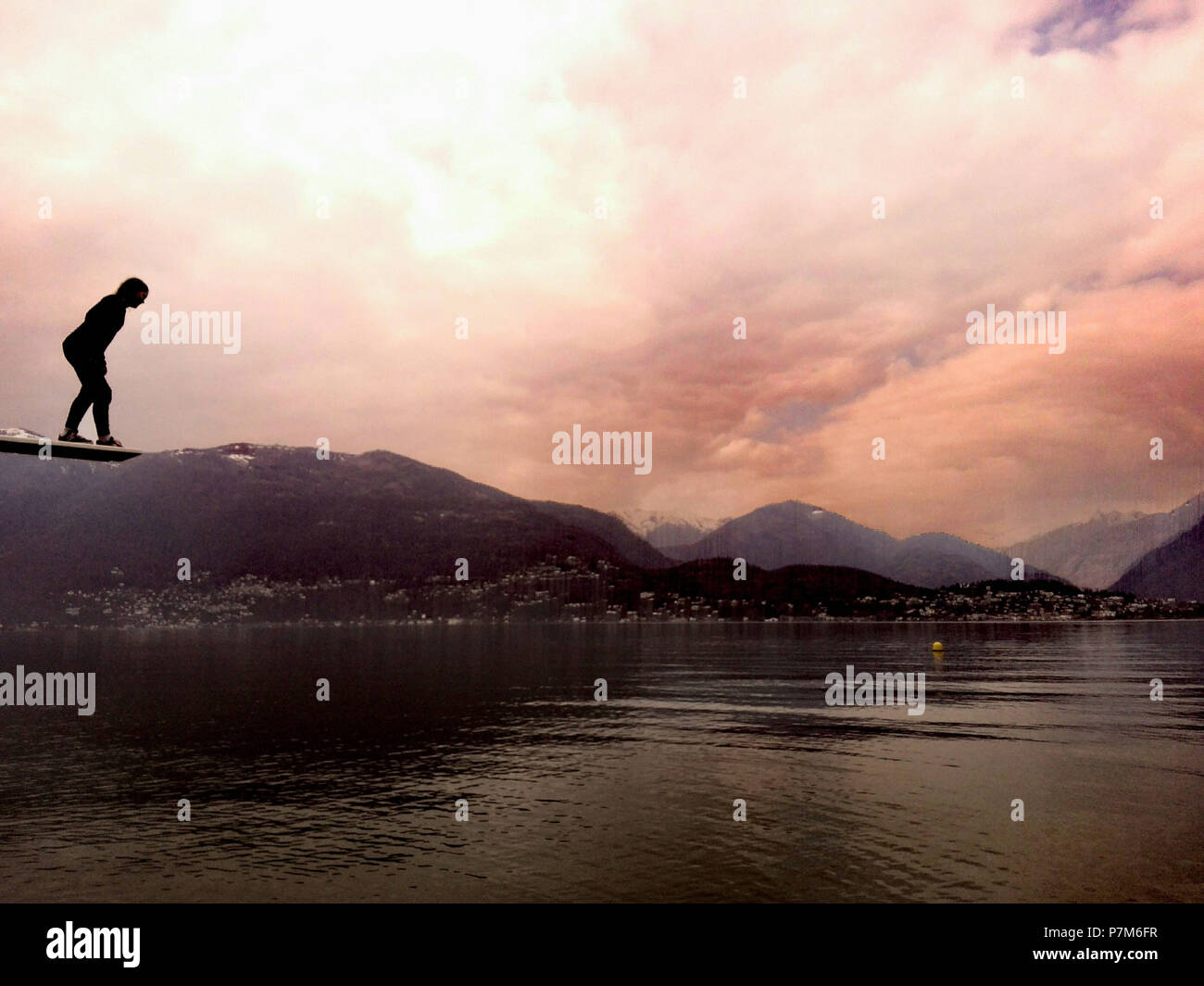 Persona su un trampolino di lancio al lago Foto Stock