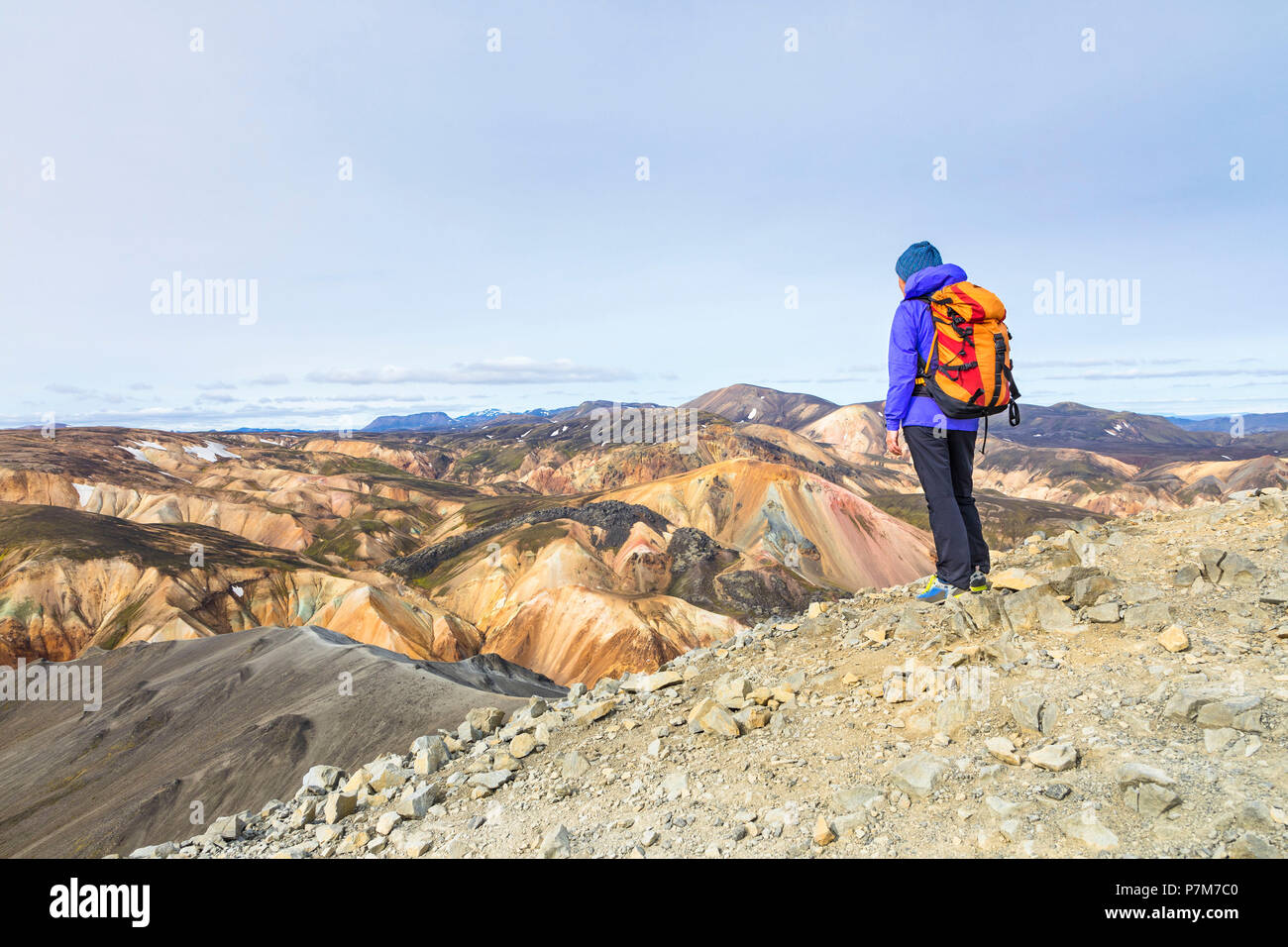 Un trekker è guardando il Landmannalaugar panorama dalla cima della montagna Blahnukur, Landmannalaugar, Fjallabak Riserva Naturale, Highlands, Regione meridionale Islanda, Europa Foto Stock