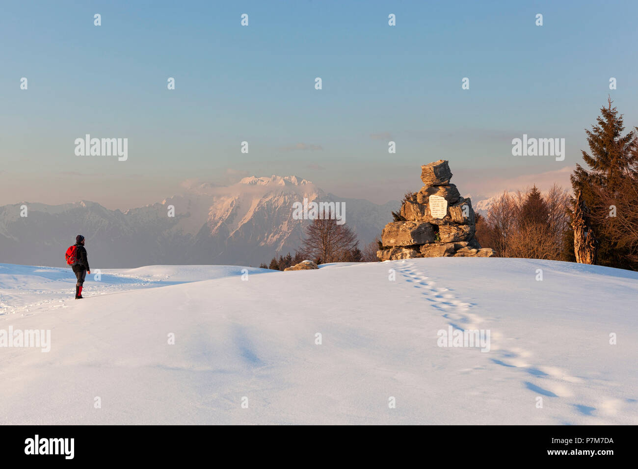 Un escursionista osserva la lapide partigiana sulla Costa Mount, Prealpi Bellunesi, Farra d'Alpago, provincia di Belluno, Veneto, Italia Foto Stock