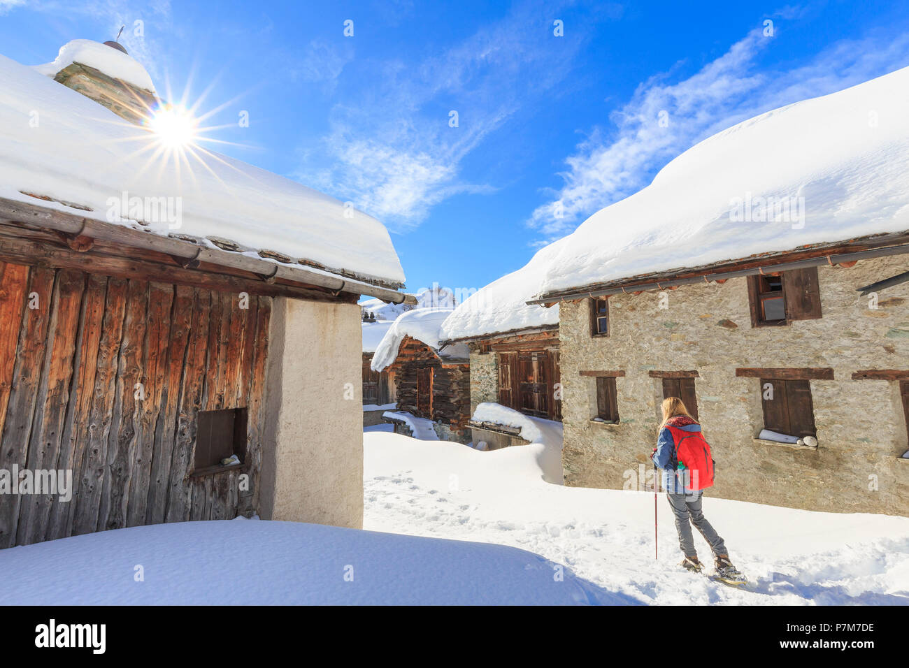 Giovane ragazza camminare con le racchette da neve nel villaggio di Grevasalvas, Engadina, Grigioni, Svizzera, Europa. Foto Stock