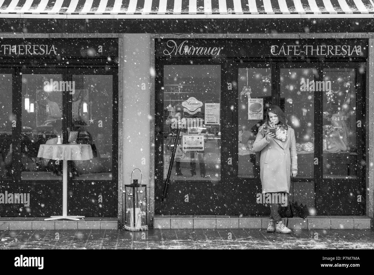 Una ragazza sul telefono nella strada principale della città, Innsbruck, in Tirolo, Austria, Europa Foto Stock