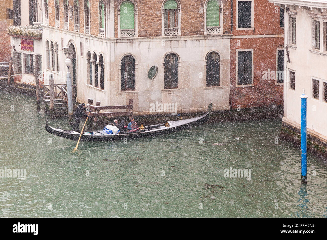 Un tradizionale gondola veneziana in Canal Grande durante una nevicata, Venezia, Veneto, Italia Foto Stock