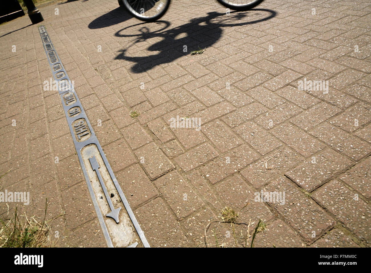Ciclista passa la linea del meridiano di Greenwich longitudine zero, Cleethorpes, Lincolnshire, Regno Unito. Foto Stock
