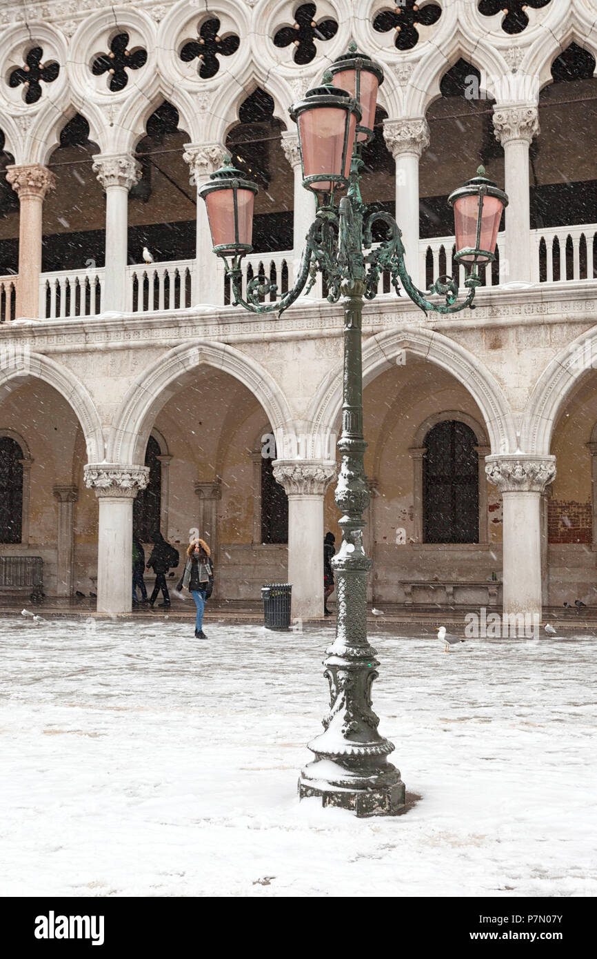 Un turista in Piazza San Marco, di fronte al Palazzo del Doge, durante una nevicata, Venezia, Veneto, Italia Foto Stock