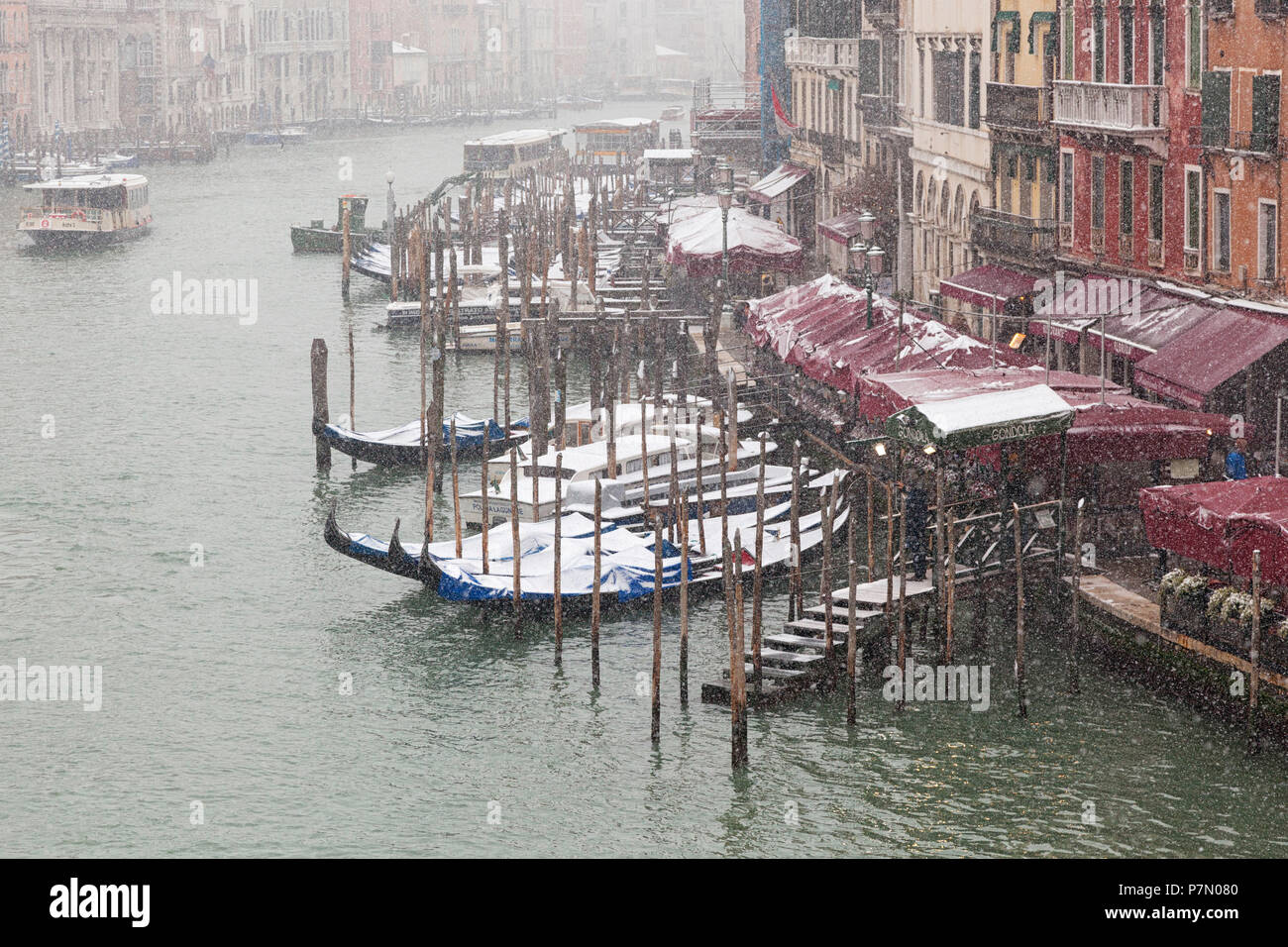 Alcune tradizionali gondole veneziane ormeggiata in Canal Grande durante una nevicata, Venezia, Veneto, Italia Foto Stock