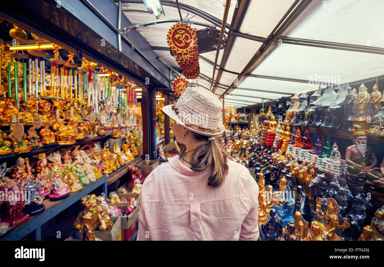 Donna turistica nel cappello e maglia rosa al mercato con negozio di souvenir a Bangkok, in Thailandia Foto Stock