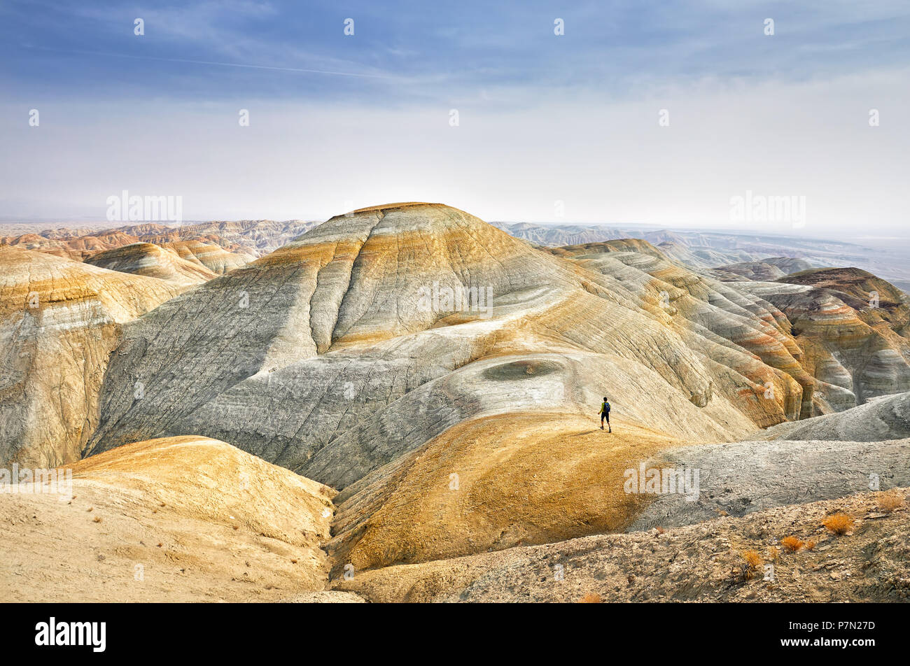 Turismo a piedi il sentiero di giallo surreale montagne del Parco Deserto Altyn Emel in Kazakistan Foto Stock