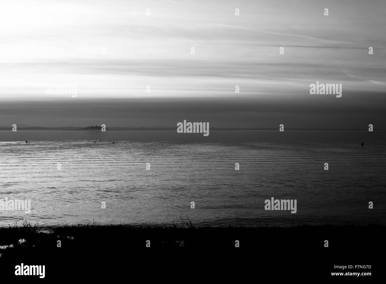Bellissima vista del lago Trasimeno (Umbria, Italia), con colline e cielo riflettendo sull'acqua Foto Stock