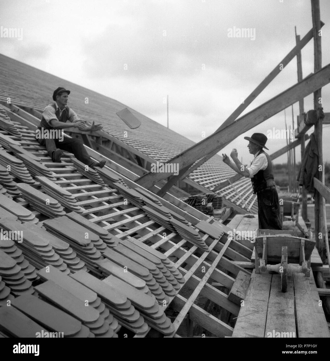 Due conciatetti scagliarsi su una casa mattonella intorno al 1950, dintorni di Friburgo, Germania Foto Stock